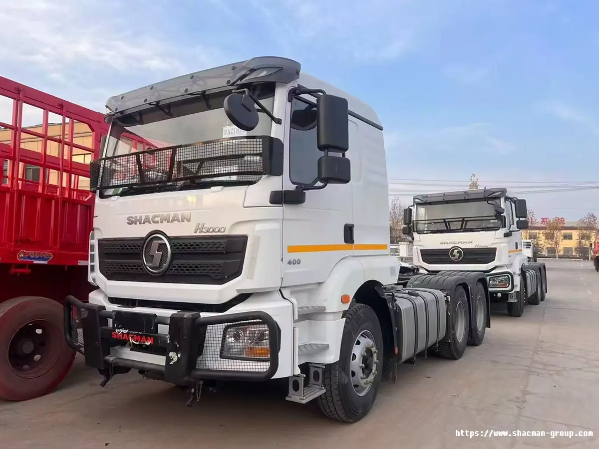 Two white SHACMAN H3000 6x4 tractor trucks parked in a row for sale in Uganda